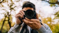 Una persona con una cámara de fotos, en una imagen de archivo