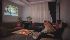 Una familia ve la televisión junto a su perro.