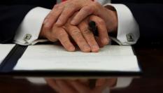 El presidente de Estados Unidos, Donald Trump, cruza sus manos sobre el decreto que acaba de firmar.