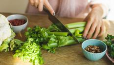 Una persona corta apio en su cocina, en una imagen de archivo.