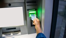 Una persona introduciendo una tarjeta en un cajero automático.