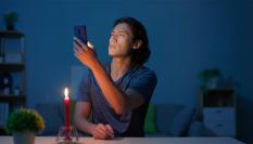 Un hombre con una vela buscando cobertura en el móvil