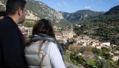Una pareja de turistas observa desde la distancia el pueblo de Valldemossa, en Mallorca.