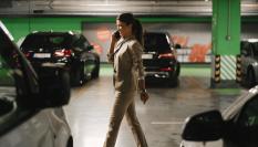Imagen de una persona caminando en busca de su coche, en un garaje subterráneo, mientras conversa por teléfono.