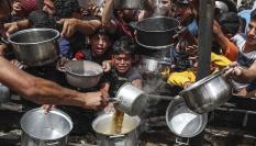 Ciudadanos palestinos se agolpan en un punto de entrega de ayuda humanitaria en Gaza.