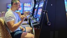 Un hombre celebra haber ganado un premio en un tragaperras.