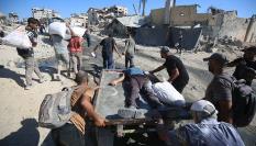 Un grupo de gazatíes traslada el cuerpo de un fallecido en las colas para pedir ayuda en Gaza.