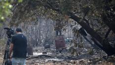 Un reportero toma imágenes tras el paso del incendio en Carucedo (León) este lunes 11 de agosto de 2025.