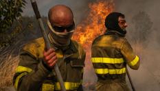 Dos voluntarios realizan labores de extinción en el incendio de Oímbra (Ourense).