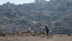 Un niño pedalea en su bicicleta en por el área de Al Eizariya, objetivo de lo planes de construcción israelíes al este de Jerusalén, que romperán la continuidad entre el norte y el sur de Cisjordania y harán aún más difícil la constitución de un Estado palestino.