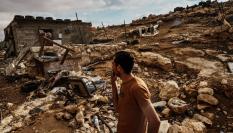 Un palestino inspecciona los daños causados por un ataque colono en su casa y sus tierras.