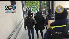 Agentes de la Policía Nacional conducen a uno de los narcotraficantes del Tren de Aragua detenidos hacia un coche patrulla, en el operativo conocido el 7 de noviembre de 2025.