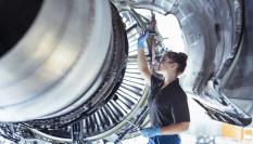 Una mecánica trabajando en el motor de un avión, en una imagen de archivo
