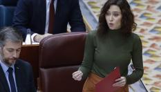 La presidenta de la Comunidad de Madrid, Isabel Díaz Ayuso (d) interviene durante el Pleno en la Asamblea de Madrid celebrado este jueves