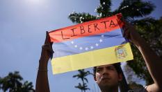 Un universitario sostiene una bandera venezolana con la palabra "Libertad" durante una protesta en el marco del Día de la Juventud Venezolana, el 12 de febrero de 2026, en Caracas.