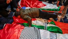 El pequeño Mustafá, sobreviviente del ataque, abraza los cuerpos de sus padres y dos hermanos, atacados por Israel, durante su funeral en Tammoun (Cisjordania), el 15 de marzo de 2026.
