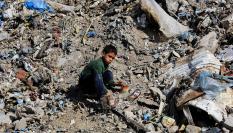 Un niño palestino se sienta en un basurero, cerca de un mercado improvisado, en la ciudad de Gaza, el 20 de abril de 2026.