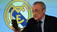 Florentino Pérez mira el móvil durante su intervención