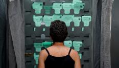 Una mujer observa varias papeletas en una cabina de votación en las elecciones andaluzas de 2022, en una imagen de archivo.