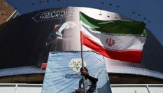 Un hombre sostiene una bandera iraní en una calle de Teherán (Irán), 15 de junio de 2026, tras el anuncio de acuerdo con EEUU.