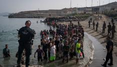 Un grupo de personas espera instrucciones de la Guardia Civil en la playa de Tarajal, tras cruzar la frontera entre España y Marruecos, el 31 de julio de 2026.