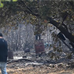 Un reportero toma imágenes tras el paso del incendio en Carucedo (León) este lunes 11 de agosto de 2025.
