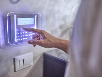 Una mujer activa la alarma de su casa.