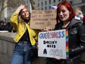 Manifestantes portan pancartas en las que se lee "la identidad queer no necesita cura", frente a Downing Street, el 10 de abril de 2022 en Londres (Reino Unido).
