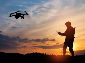 Fotomontaje de un soldado en sombras maniobrando con un dron.