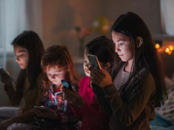 Best friends scrolling through social media during sleepover party.