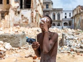 Un joven cubierto de polvo de cal y sudor sostiene billetes mientras descansa de la limpieza de escombros de un local derrumbado en La Habana (Cuba), el 11 de junio de 2026.