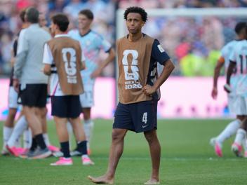 Tyler Adams, tras la eliminación de Estados Unidos. Al fondo, los jugadores belgas celebran el pase a cuartos.