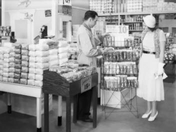Un empleado ayuda a una mujer en un supermercado de 1930