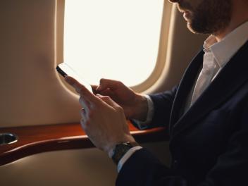 Hombre en jet privado haciendo uso del móvil.