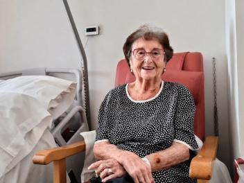 Una anciana recostada en una butaca junto a una cama de hospital mira sonriente a cámara: es Rosita Rochina