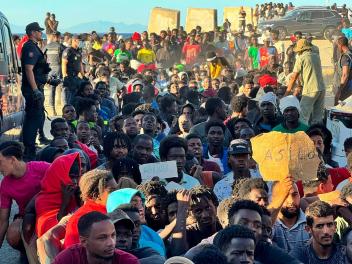 La Cruz Roja y la organización Sur Sur distribuyen alimentos básicos entre los migrantes que cruzaron a Ceuta, ante la mirada de la Policía, el 3 de agosto de 2026.