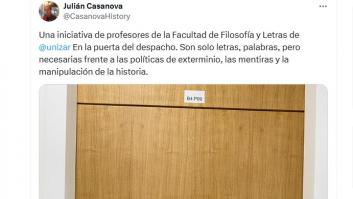 Un catedrático muestra el cartel que han colgado unos profesores en el despacho en la Universidad de Zaragoza