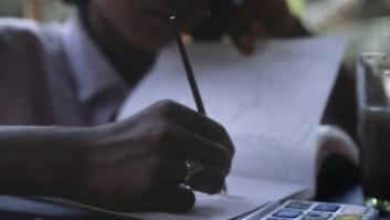 Una mujer dibujando en su cuaderno