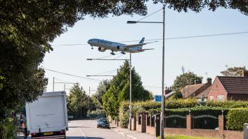 Avión sobrevolando un conjunto de casas.
