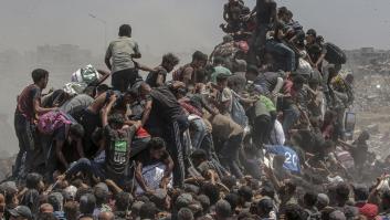 Palestinos intentan recoger sacos de harina de un camión de ayuda humanitaria cerca de un punto de distribución de alimentos en Zikim, al norte de Gaza, el 27 de julio de 2025.