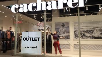 Una mujer limpiando el escaparate del outlet de Cacharel