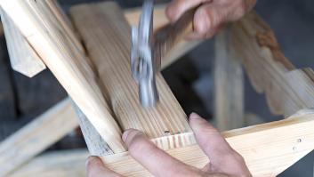 Un carpintero martillando clavos de metal en una construcción de madera