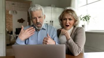 Una pareja de ancianos sorprendidos por las malas noticias en la computadora portátil.