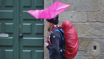 Una persona se protege de la fuerte lluvia en la plaza del Obradoiro, en Santiago de Compostela.