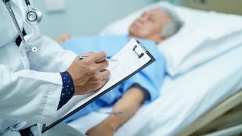 Médico escribiendo el diagnóstico en el portapapeles mientras que la anciana de edad avanzada asiática o anciana acostada en la cama en la sala del hospital de enfermería : concepto médico fuerte saludable.