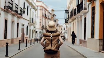 Una mujer joven con mochila buscando dirección mientras viaja