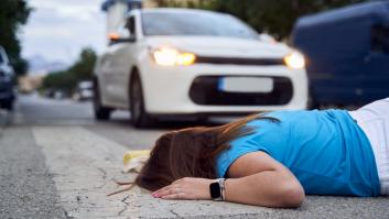 Side view of an unrecognizable young woman lying on the ground at a crosswalk after being hit by a car. Concept of hit-and-run and traffic accidents in the city.