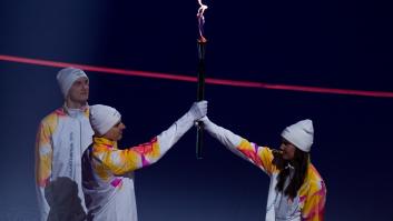 Los atletas del equipo de Italia entregan la llama olímpica al siguiente grupo de portadores de la antorcha durante la ceremonia de apertura de los Juegos Olímpicos de Invierno