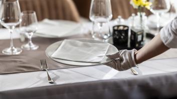 Una camarera colocando los platos en la mesa