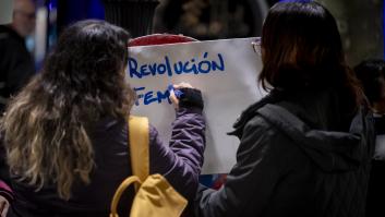 Una joven escribiendo en un cartel, en Madrid, "Revolución feminista".